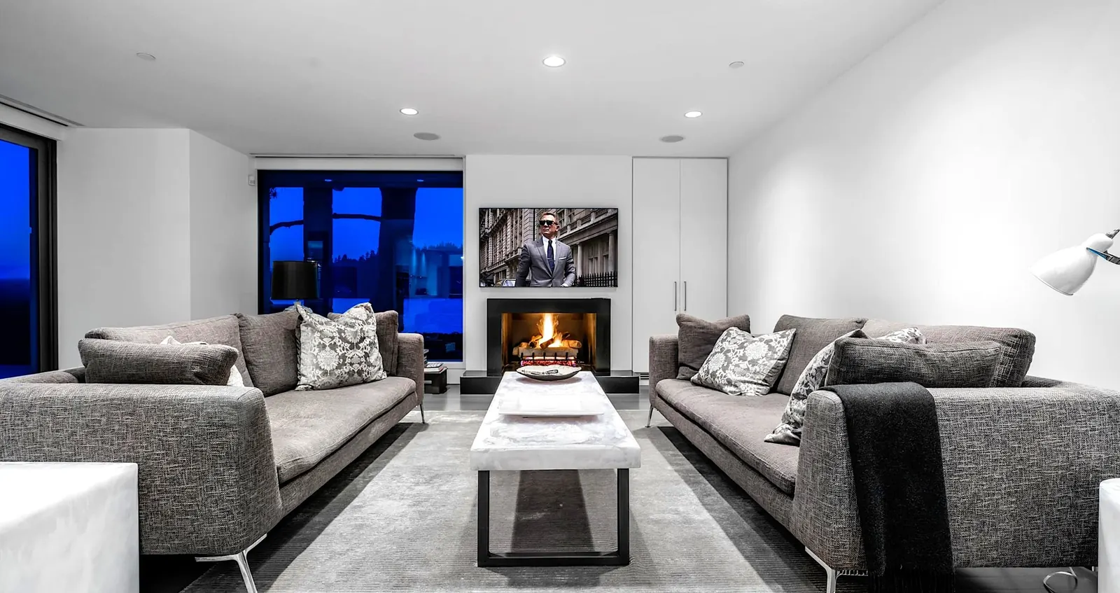 A West Vancouver living room with a modern fireplace, built-ins and grey sofas.